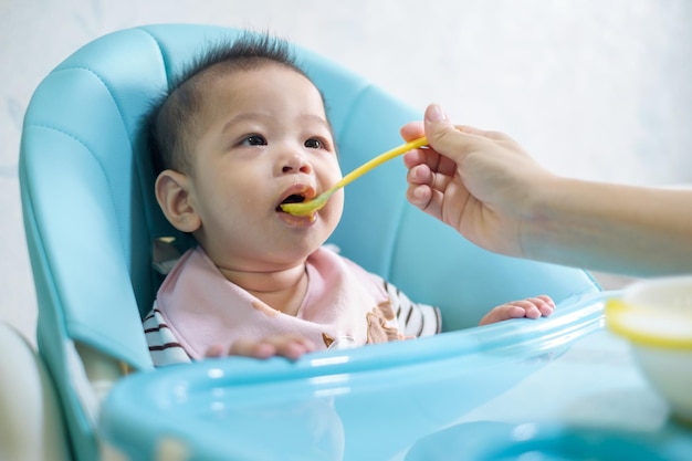 Siedmiomiesięczne dziecko siedzi i karmi się z karmiącą go mamą