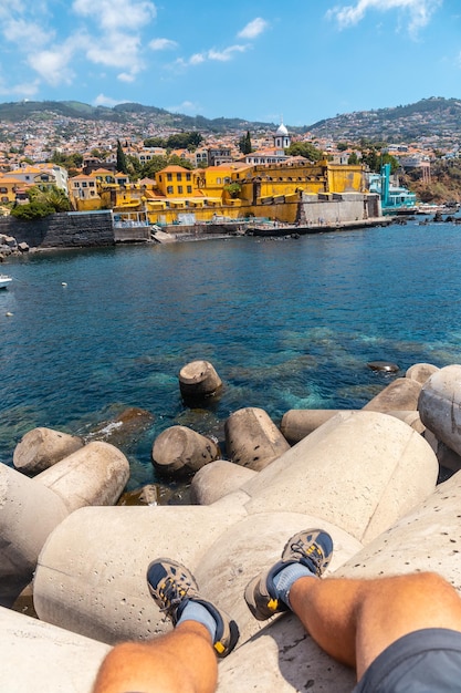 Siedząc patrząc na żółty fort nad morzem z Forte de Sao Tiago na plaży Funchal Madera