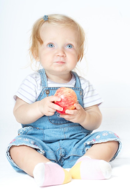 Siedzące dziecko z jabłkiem