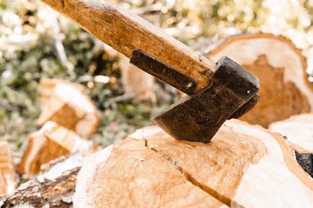 Zdjęcie siekiera i drewno opałowe na podwórku siekiera w pniu stos drewna opałowego i pniaka drewno opałowe na zimę