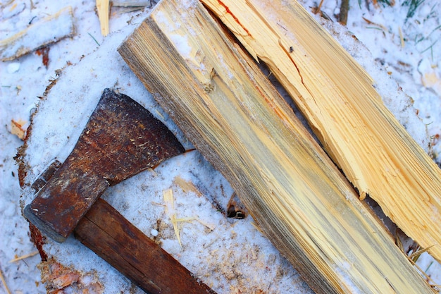 Zdjęcie siekiera i drewno opałowe zimą