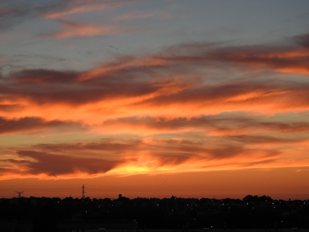 Zdjęcie silhoueta krajobrazu miejskiego na tle dramatycznego nieba podczas zachodu słońca