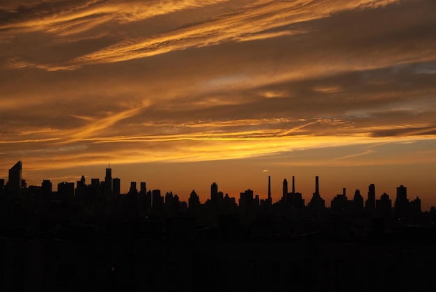 Silhoueta miejskiej panoramy na chmurnym niebie podczas zachodu słońca