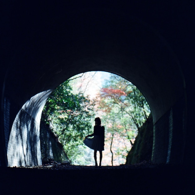 Zdjęcie silhueta kobiety stojącej poza tunelem