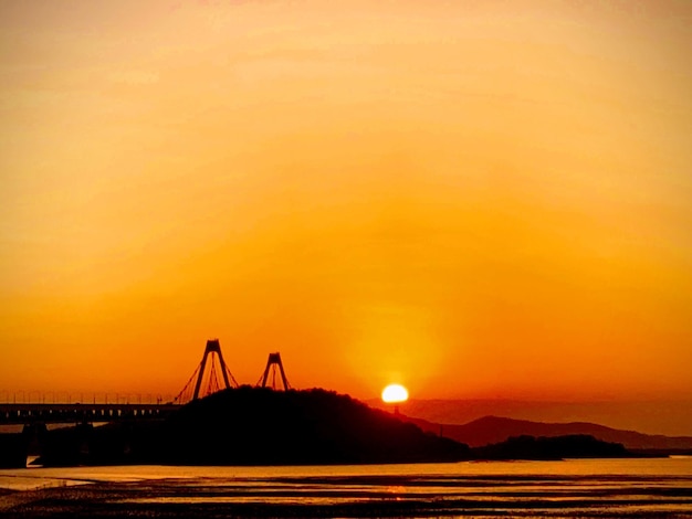 Zdjęcie silhueta mostu nad zatoką na pomarańczowym niebie