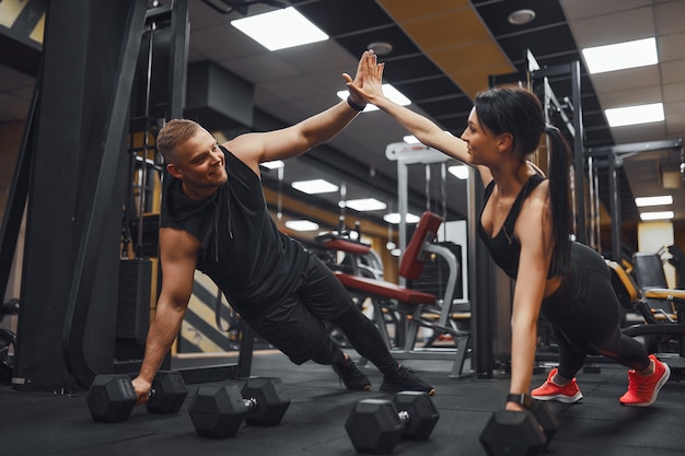 Silna I Piękna Para Fitness Lekkoatletycznego W Strojach Treningowych, Robi ćwiczenia Push-up I Daje Sobie Piątkę