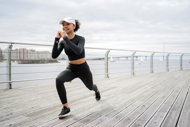 Silna, wysportowana kobieta ćwiczy z zegarkiem z bransoletką fitness na ramieniu