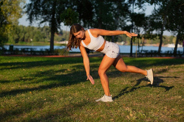 Silna, wysportowana kobieta o atletycznej sylwetce, wykonująca pilates i ćwiczenia rozciągające