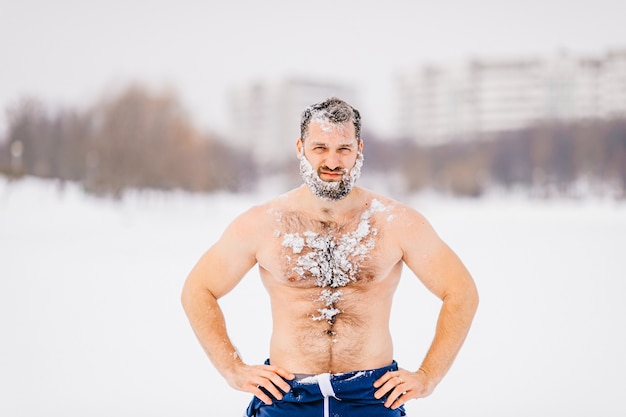 Silny, brutalny nagi mężczyzna z brodą w śniegu pozowanie na zewnątrz