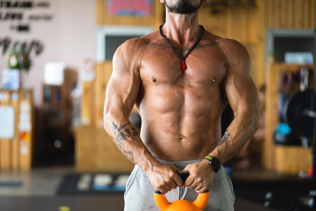 Silny mężczyzna używający kettlebell na siłowni