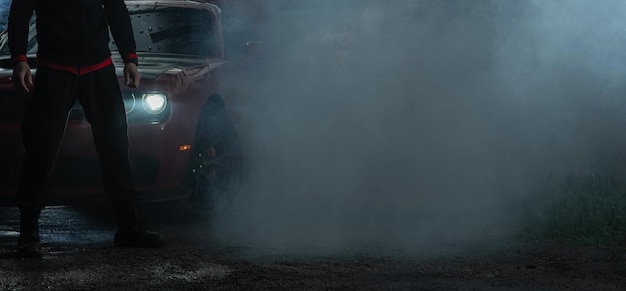 Silny samochód i kierowca pokryci dymem po silnym wypaleniu