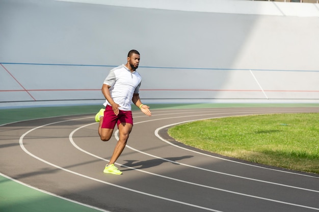 Silny, zdecydowany, sportowy mężczyzna na bieżni