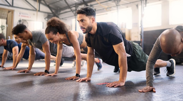Siłownia fitness z mężczyznami i kobietami wykonującymi mocną deskę i ćwiczeniami cardio i wytrzymałości mięśniowej w klasie ćwiczeń Zdrowie i różnorodność trening ciała oraz zdrowe aktywne wyzwanie