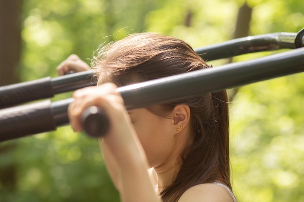 Siłownia w naturze Młoda dziewczyna uprawia sport w parku na świeżym powietrzu