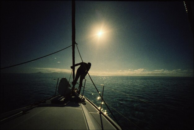 Zdjęcie siluweta człowieka w łodzi na spokojnym morzu