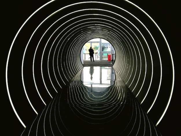 Zdjęcie siluweta osoby widziana przez oświetlony tunel