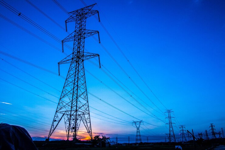 Zdjęcie siluweta wieczornego pylonu przesyłowego energii elektrycznej