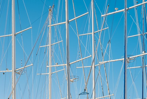 Zdjęcie siluwety jachtów w przystani na tle jasnego niebieskiego nieba
