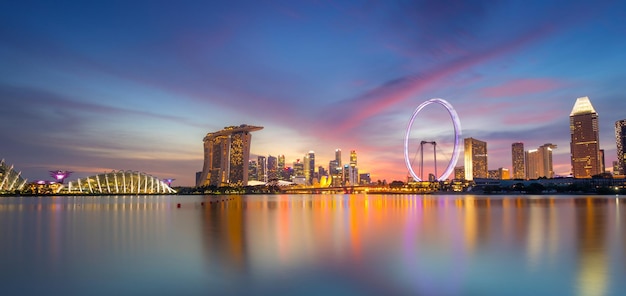 Zdjęcie singapur skyline i widok na drapacze chmur w marina bay o zachodzie słońca wieczorem singapur