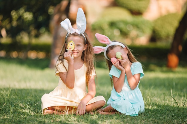 Zdjęcie siostry trzymające jaja wielkanocne siedząc na trawniku
