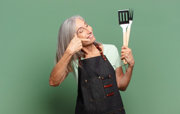 Siwe włosy ładna kobieta szefa kuchni z grilla