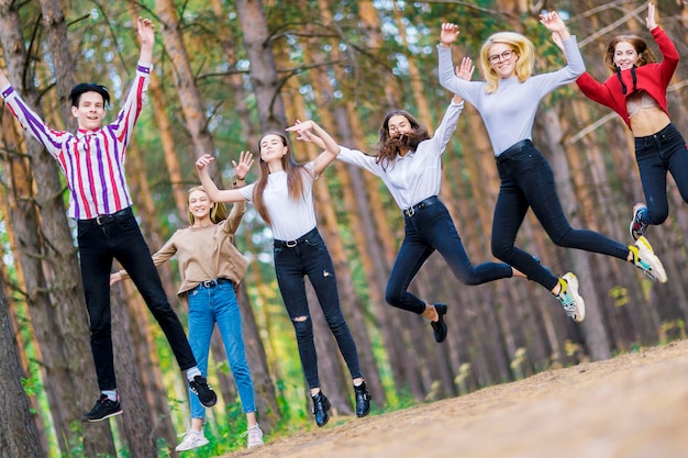 Skaczące nastolatki 1519 lat w wesołym nastroju w letnim lesie