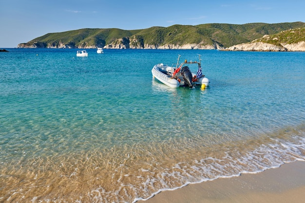 Zdjęcie skalista plaża z krajobrazem łodzi sithonia grecja