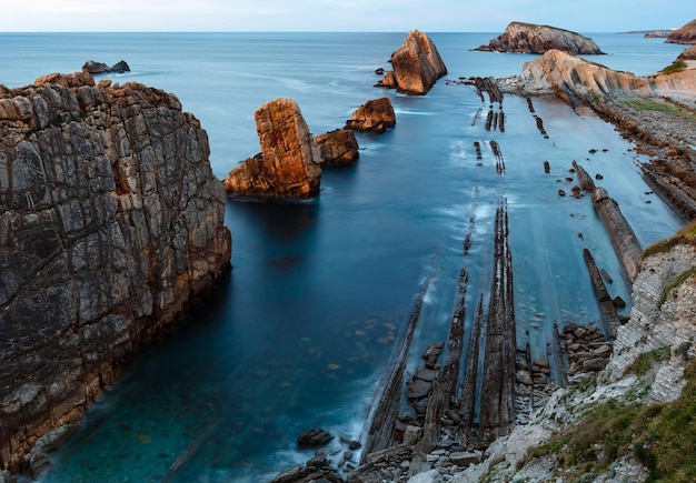 Skaliste wybrzeże Oceanu Atlantyckiego w pobliżu wieczornego widoku plaży Portio (Pielagos, Kantabria, Hiszpania).