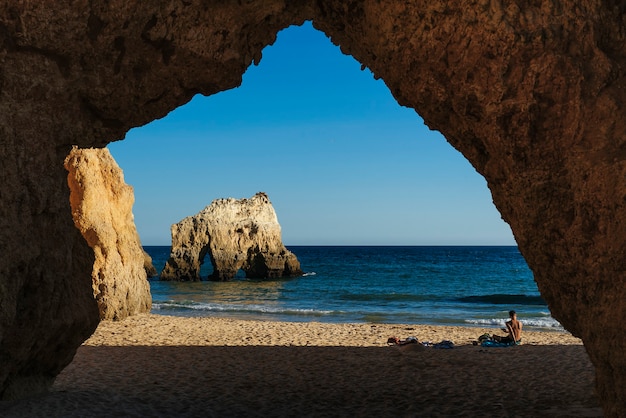 Zdjęcie skały i shilouettes na plaży three brothers w algarve, portimao, portugalia