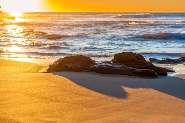 Skały na plaży o zachodzie słońca