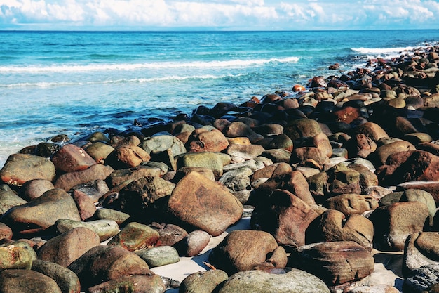 Skały na plaży ze słońcem na niebie