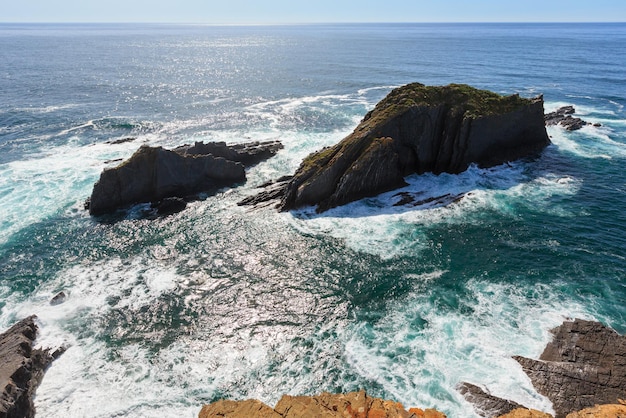 Skały w pobliżu brzegu. Letni wieczór krajobraz Oceanu Atlantyckiego (Aljezur, Algarve, Portugalia).