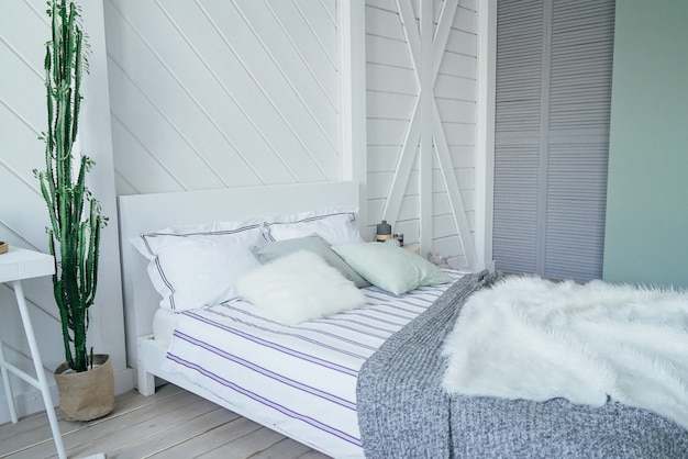 Zdjęcie skandynawski nowoczesny przytulny ekologiczne wnętrze, biały stół i lustro w sypialni