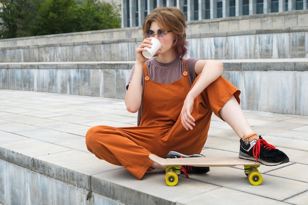 Skater, nastolatka odpoczywająca, pijąca kawę na świeżym powietrzu.