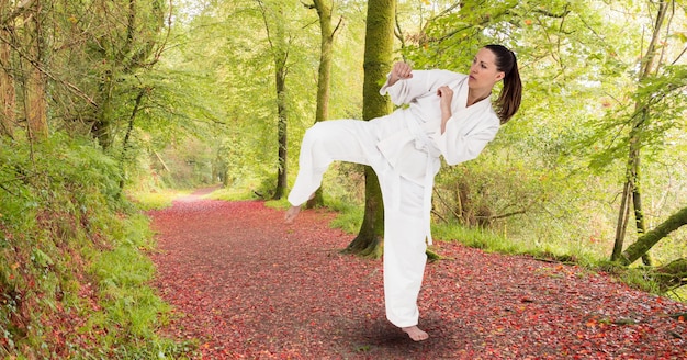 Skład kobiecej artystki karate ćwiczącej w parku z miejscem na kopię