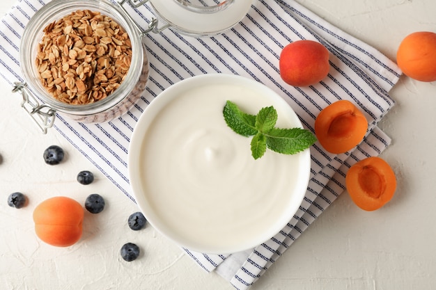 Skład z granola, jogurtem i świeżymi owoc na białego cementu tle