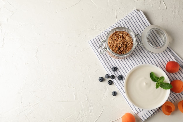 Skład z granola, jogurtem i świeżymi owoc na białego cementu tle