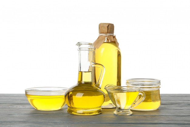 Skład z olejem słonecznikowym na drewnianym stole na białym tle