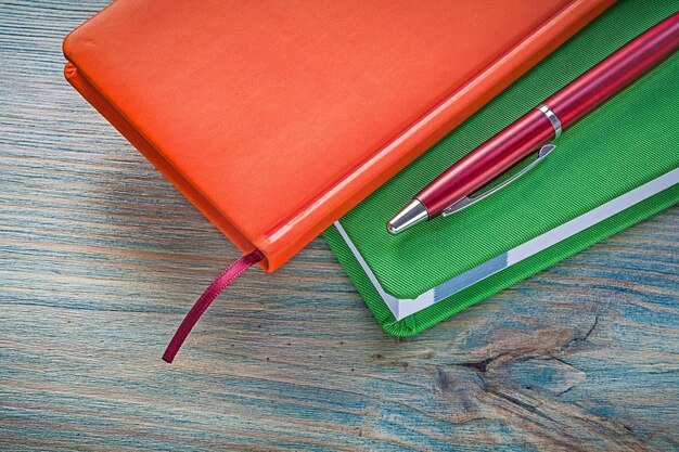 Skład zamkniętych notatników długopis na koncepcji edukacji drewnianej tablicy