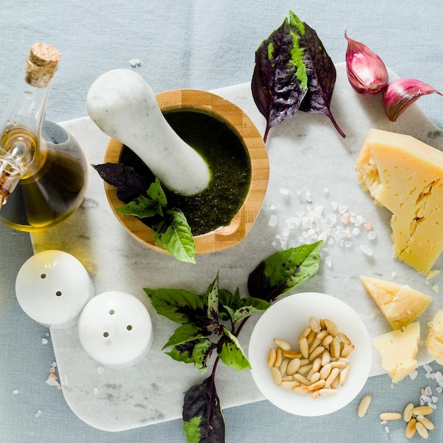 Składniki do przygotowania włoskiego bazyliowego fioletowego pesto z serem na lnianym niebieskim obrusie