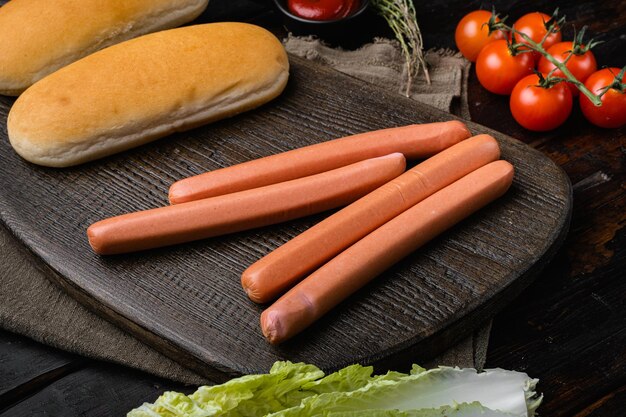 Zdjęcie składniki na hot dogi na starym ciemnym drewnianym stole w tle