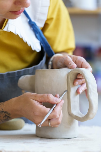 Zdjęcie sklep z ceramiką mały biznes proces modelowania i kształtowania glinianego słoika w pracowni ceramicznej lub warsztacie