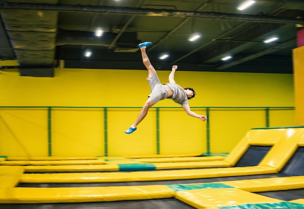 Skoczek na trampolinie wykonuje skomplikowane ćwiczenia akrobatyczne oraz salta na trampolinie.