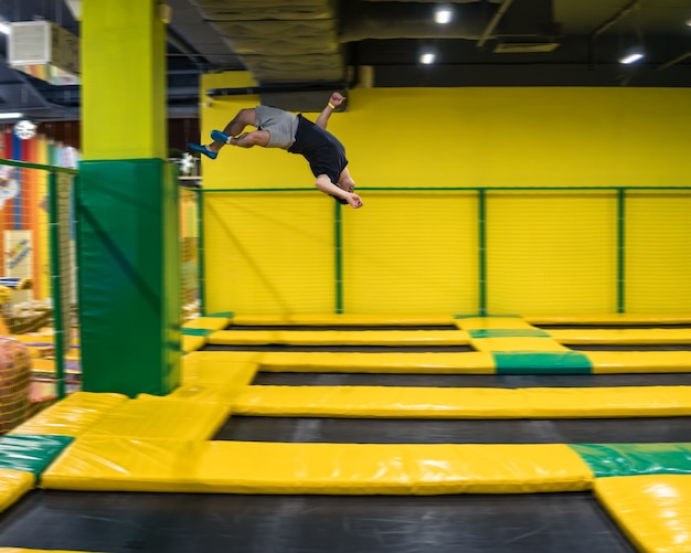 Skoczek na trampolinie wykonuje skomplikowane ćwiczenia akrobatyczne oraz salta na trampolinie.