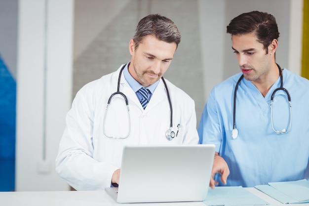 Skoncentrowani lekarze pracujący na laptopie