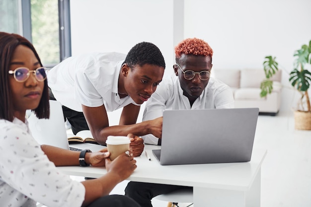 Skoncentrowani na projekcie przy użyciu laptopa Grupa afroamerykańskich biznesmenów pracujących razem w biurze