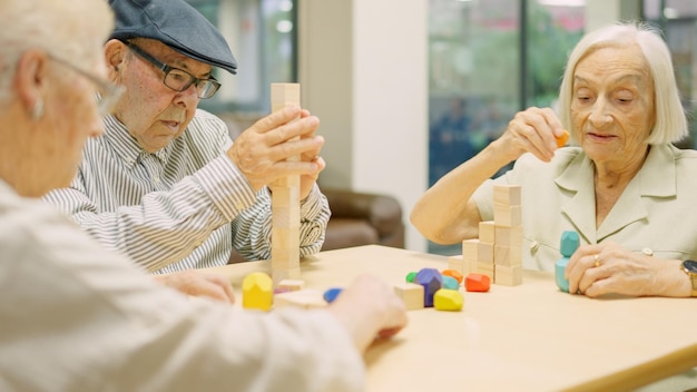 Skoncentrowani seniorzy rozwiązują gry umiejętności mózgowych z kawałkami w geriatrii