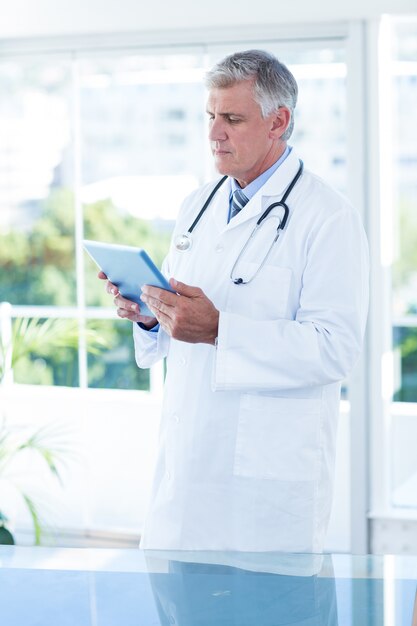 Zdjęcie skoncentrowany lekarz trzymając tabletkę