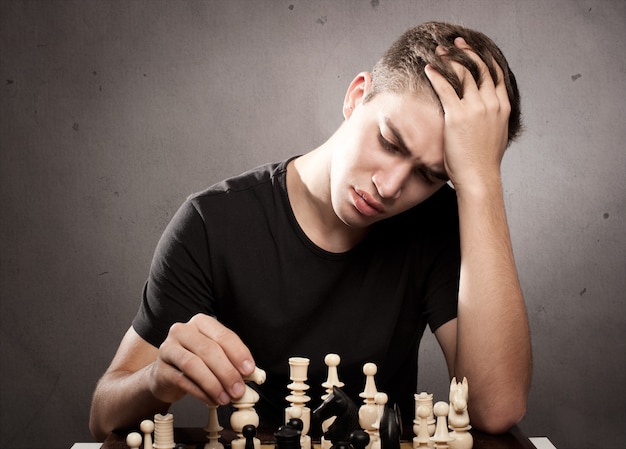 skoncentrowany młody człowiek gra w szachy
