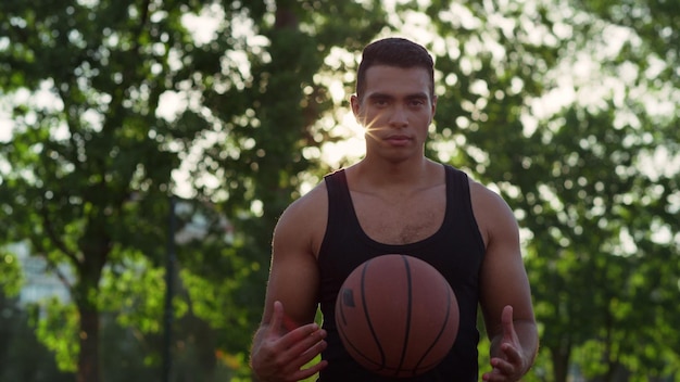 Skoncentrowany sportowiec rasy mieszanej ćwiczący koszykówkę na samym placu zabaw